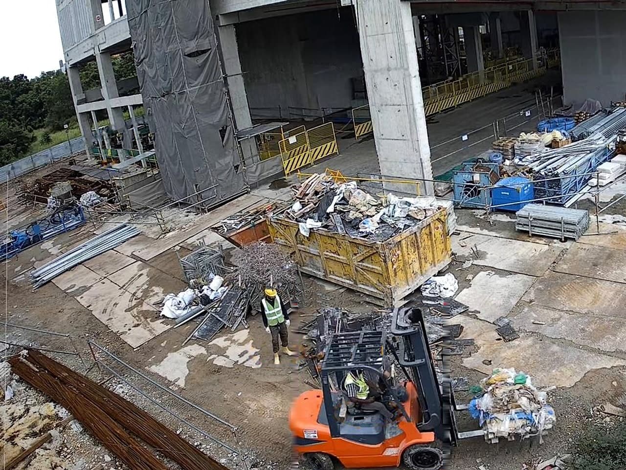 Outdoor yard camera: a forklift carrying a load with its danger area drawn on the ground, and a pedestrian standing inside the area flagged by Ailytics.